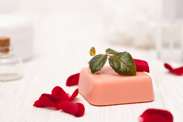 salt, rose water from rose petals with your hands on a white woo