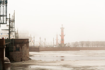 Rostral columns on the spit Vasilevsky Island in the fog in winter.