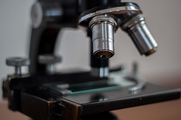 A young doctor study at the microscope, carefully holding a copy