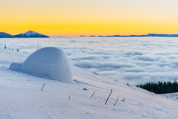 yurt at sunset in winter fog mountains.