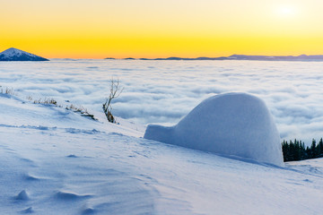 yurt at sunset in winter fog mountains.