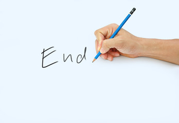 Hand holding a pencil on a white paper background, writing with pencil for word " End "