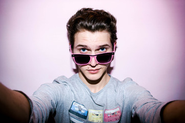 Attractive emotional  young man with glasses in studio