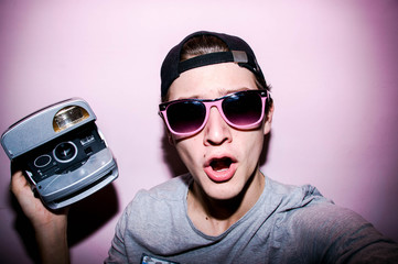 Portrait of the guy pink backgrounud with retro camera