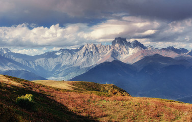 Autumn landscape and snow-capped mountain peaks. View of the mou