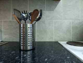 Kitchen utensils in a metal tin pot