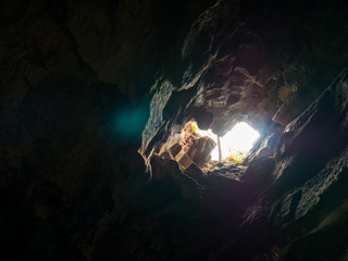Mystery cave hole with beautiful sunlight in deep forest