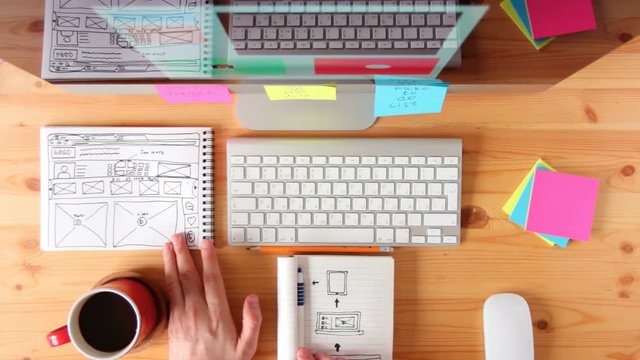 Top view. Webmaster draws the future layout of the web pages in the sketch book.