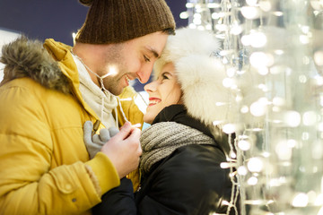 Romantic couple hugging against lights