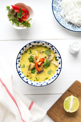 Thai soup with coconut milk and chicken meat on white table