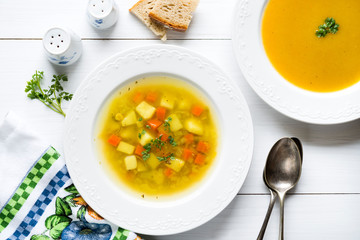 Vegetable soup with bread and fresh parsley, top view