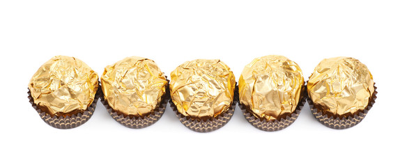 Line of golden confection candies isolated