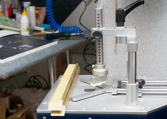 Craftsman working on frame in frame shop. Professional framer hand holding frame angle