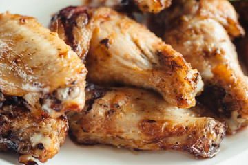 Chicken wings with sauce on plate on wooden table