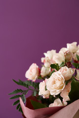 Beautiful roses bouquet on purple background, space for texting