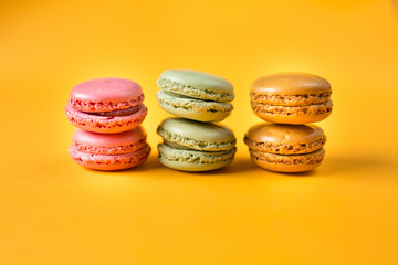 colorful macarons on yellow background