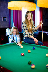 two girls playing billiard