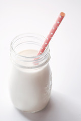 Milk in a glass jar with pink straw
