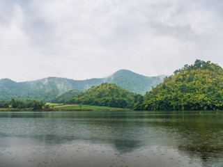 Fototapeta na wymiar Beautiful tranquil lake and mountain covered with fog