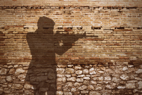 old brick wall with gunman shadow