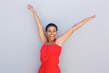beautiful young black woman smiling with arms raised