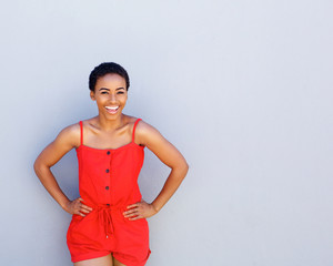 cooly young african american woman laughing against gray wall