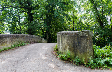 Old historic stone bridge at walk path in park hike trail at wat