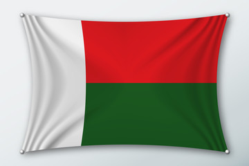 Madagascar national flag. Symbol of the country on a stretched fabric with waves attached with pins. Realistic vector illustration.