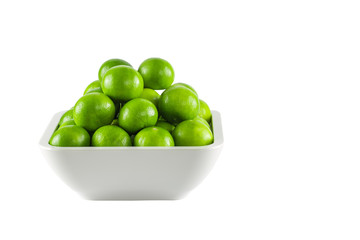 Green lemon in square bowl on white