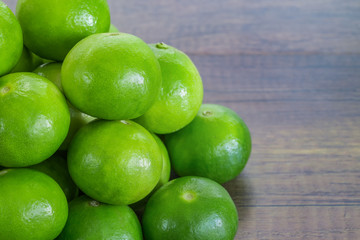 stack of green lemon on wood table
