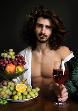 photo portrait of a handsome guy with long curly hair at the table with glass of red drink and fruits