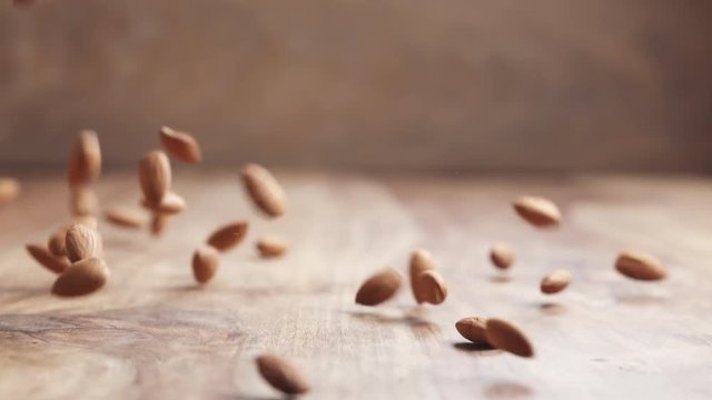 Slow motion of almonds falling on wooden table, 180fps prores footage