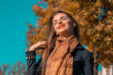 beautiful girl closing her eyes stands in the sunshine and smiles