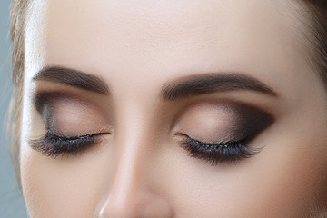 Closeup image of closed woman eye with beautiful bright makeup, smoky eyes