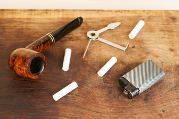 Obraz na płótnie Canvas Smoking pipe on a wooden table. Aroma. Top view