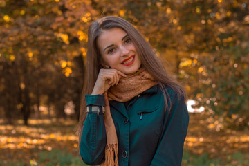 young attractive girl stands in the Park of his head and smiles