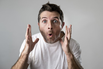 young attractive man astonished amazed in shock surprise face expression and shock emotion