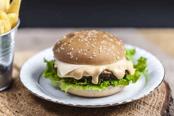 Fresh french fries, chips with tasty burger background