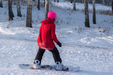 Fototapeta na wymiar Girl snowboarding on the mountain slope