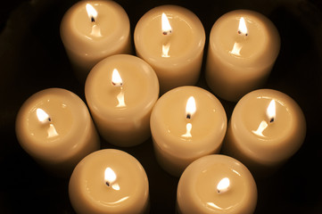 Burning wax candles closeup on dark background