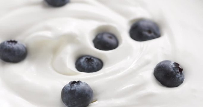 Blueberries in organic yogurt rotating loop video, 4k prores footage
