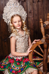 Russian girl in a folk russian dress on wooden background
