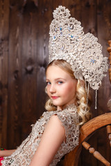 Russian girl in a folk russian dress on wooden background