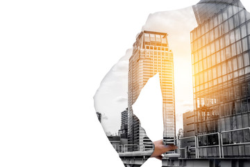 Double exposure businessman akimbo and city downtown