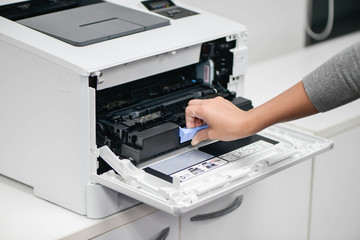 Woman hand is reloading the printer cartridge