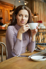 Beautiful woman eating chocolate cake at cafe