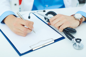 Male medicine doctor hand holding silver pen writing something on clipboard closeup. Ward round, patient visit check, medical calculation and statistics concept. Physician ready to examine patient