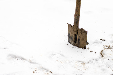 shovel sticking in the snow on a cold day