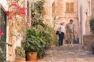 tourists walking on typical mediterranean street in small town