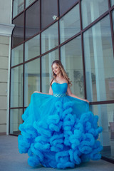 Fototapeta premium Beautiful model in a blue dress over neutral background